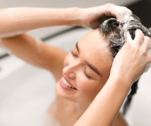 Woman Washing Head Covered With Foam Taking Bath In Bathroom/ envato